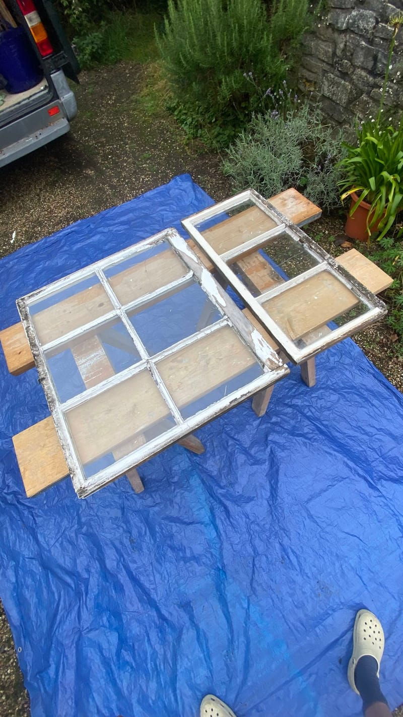 Two sashes on trestles with old, flaking paint