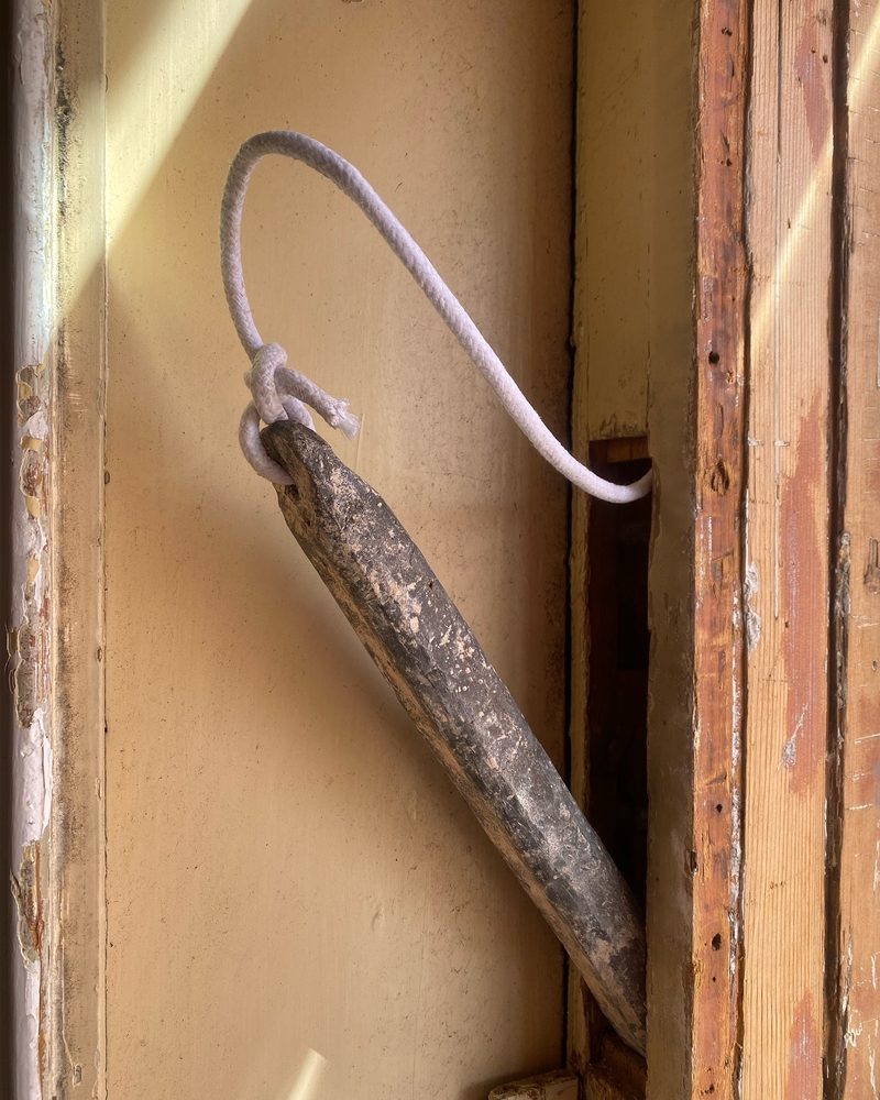 New cotton sash cord tied to the original weight, coming out of the pulley-stile pocket