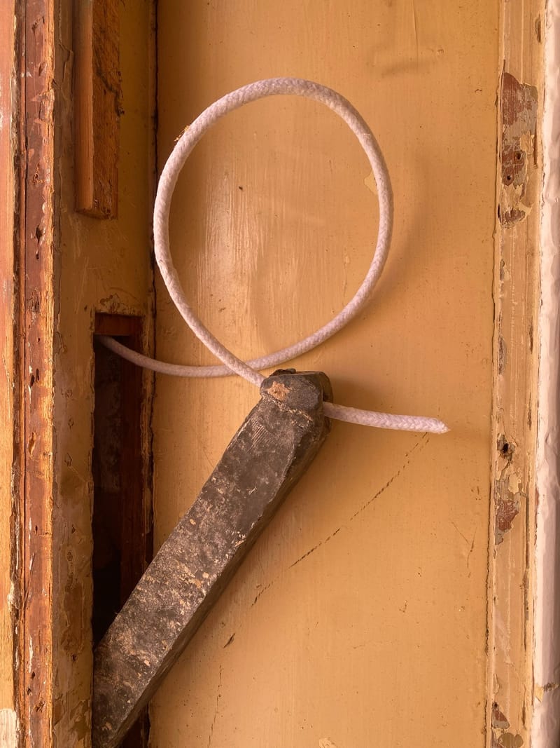New sash cord being tied to an antique lead weight
