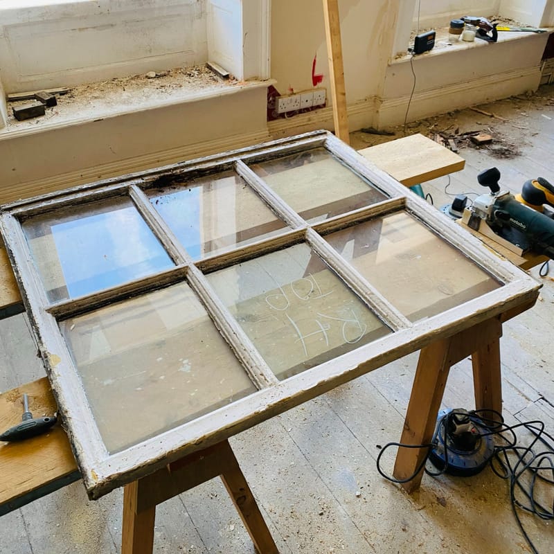 Six-pane sash being worked on, resting on trestles